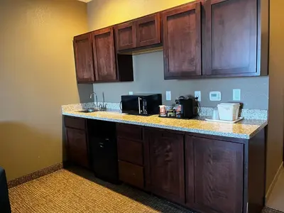 a kitchen with wooden cabinets and a counter top at Comfort Suites Denver International Airport in Denver