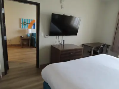 a bedroom with a bed and a flat screen tv at MainStay Suites Denver International Airport in Denver