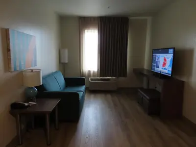 a living room with a couch and a tv at MainStay Suites Denver International Airport in Denver
