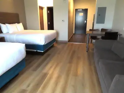 a hotel room with two beds and a desk at MainStay Suites Denver International Airport in Denver