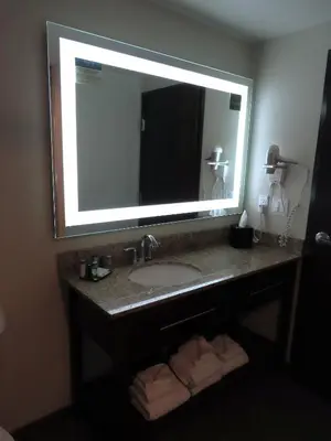 a bathroom with a sink and a large mirror at MainStay Suites Denver International Airport in Denver