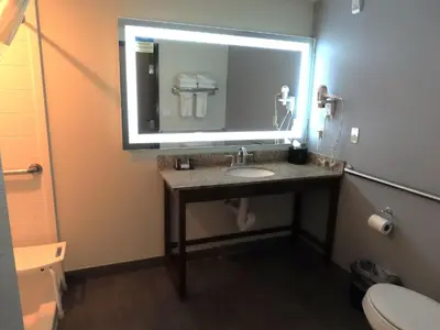 a bathroom with a sink and a large mirror at MainStay Suites Denver International Airport in Denver