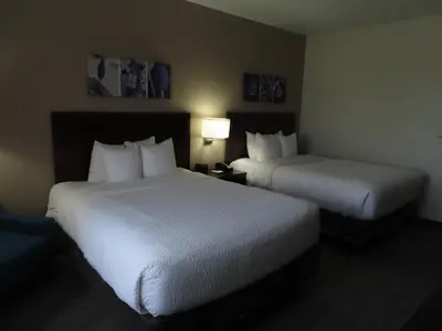 two beds in a hotel room with white sheets at Sleep Inn & Suites Denver International Airport in Denver