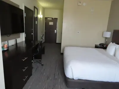 a hotel room with a white bed and a desk at Sleep Inn & Suites Denver International Airport in Denver