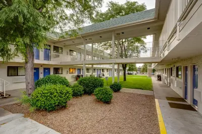 an outside view of a building with trees and bushes at Motel 6-Wheat Ridge, CO - West - Denver North in Wheat Ridge
