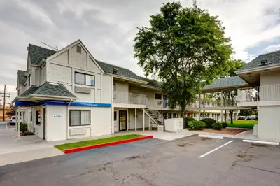 an apartment building with a parking lot in front of it at Motel 6-Wheat Ridge, CO - West - Denver North in Wheat Ridge