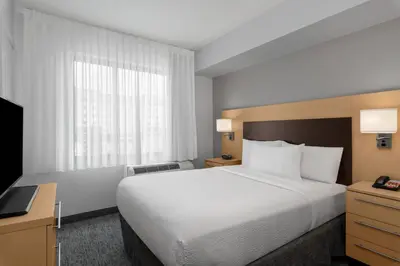 a hotel room with a large bed and a television at TownPlaces Suite Denver Airport at Gateway Park in Denver