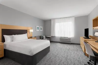 a hotel room with a bed and a television at TownPlaces Suite Denver Airport at Gateway Park in Denver