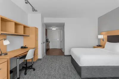 a hotel room with a bed and a desk and a bedroom at TownPlaces Suite Denver Airport at Gateway Park in Denver