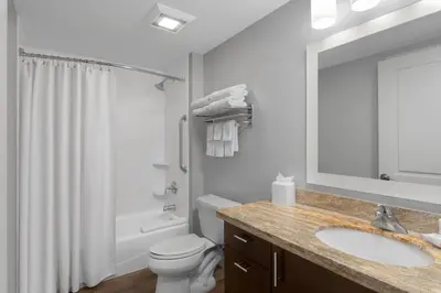 a bathroom with a sink and a toilet and a mirror at TownPlaces Suite Denver Airport at Gateway Park in Denver