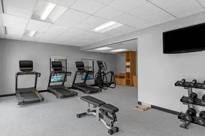 a gym with several exercise machines and a flat screen tv at TownPlaces Suite Denver Airport at Gateway Park in Denver