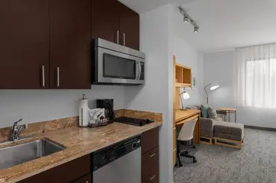 a kitchen with a sink and a desk in a room at TownPlaces Suite Denver Airport at Gateway Park in Denver