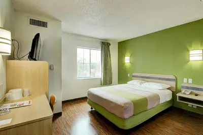 a hotel room with a large bed and a desk at Super 8 by Wyndham Aurora East in Aurora