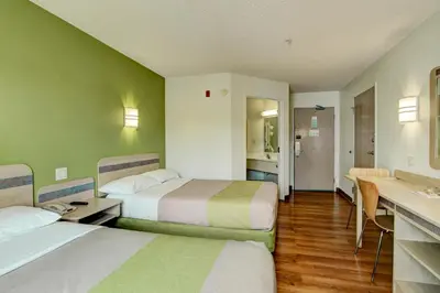 a hotel room with two beds and a kitchen at Super 8 by Wyndham Aurora East in Aurora