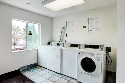 a laundry room with a washer and dryer and a window at Super 8 by Wyndham Aurora East in Aurora