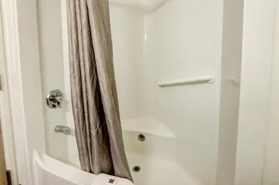 a bathroom with a shower curtain next to a toilet at Super 8 by Wyndham Aurora East in Aurora