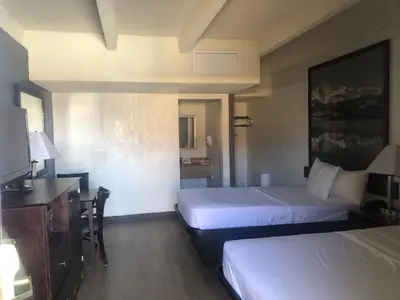 a hotel room with two beds and a desk at Budget Inn Denver Downtown in Denver