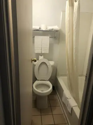 a small bathroom with a toilet and a bath tub at Budget Inn Denver Downtown in Denver