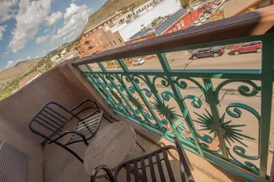 a balcony with a bench and a view of a street at Table Mountain Inn in Golden