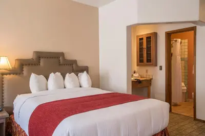 a bedroom with a large bed with a red blanket at Table Mountain Inn in Golden