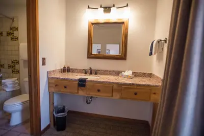 a bathroom with a sink with a mirror and a toilet at Table Mountain Inn in Golden