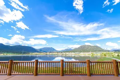 a view of a lake from a wooden fence at The Estes Park Resort in Estes Park