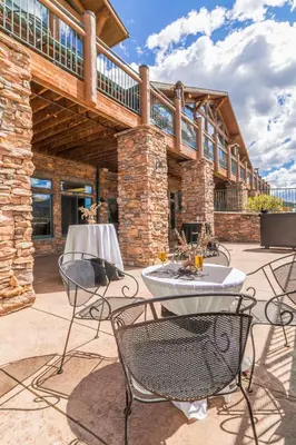 a patio with two tables and chairs in front of a building at The Estes Park Resort in Estes Park