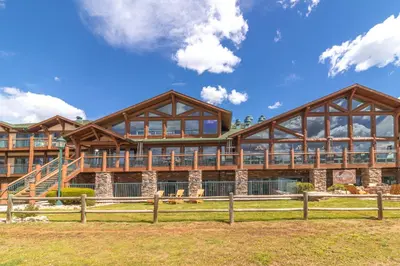 a large log home with a large deck at The Estes Park Resort in Estes Park