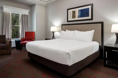 a hotel room with a bed and a red chair at Lady Luck Casino Black Hawk in Black Hawk