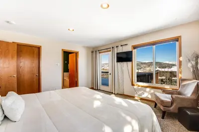 a bedroom with a large bed and a large window at Twenty Grand Chalet in Silverthorne
