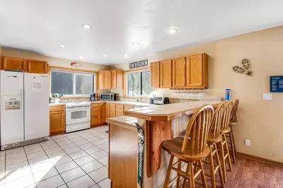 a kitchen with a white refrigerator and wooden cabinets at Twenty Grand Chalet in Silverthorne