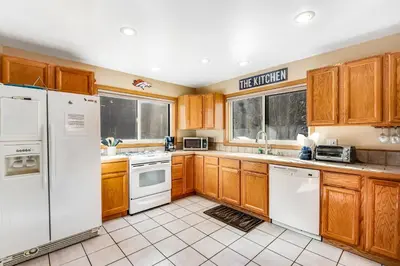 a kitchen with wooden cabinets and white appliances at Twenty Grand Chalet in Silverthorne