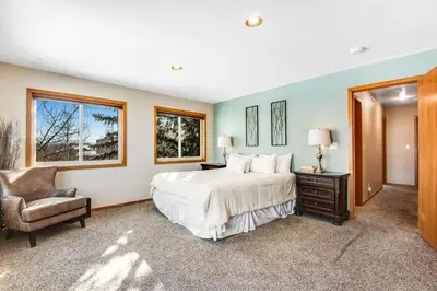 a bedroom with a large bed and a chair at Twenty Grand Chalet in Silverthorne