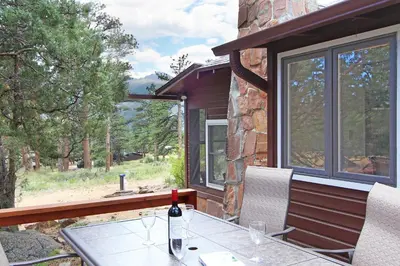 a bottle of wine sitting on a table on a patio at Blue Jay Bungalow in Estes Park