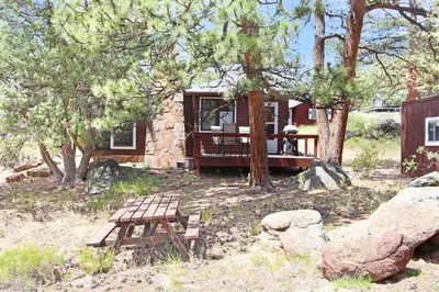 a house with a picnic table in front of it at Blue Jay Bungalow in Estes Park
