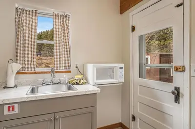 a kitchen with a sink and a microwave at Blue Jay Bungalow in Estes Park