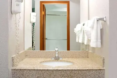 a bathroom with a sink and a mirror at Super 8 by Wyndham Denver Stapleton in Denver