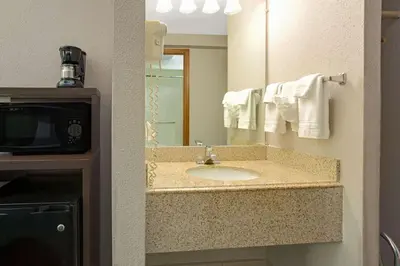 a bathroom with a sink and a mirror at Super 8 by Wyndham Denver Stapleton in Denver