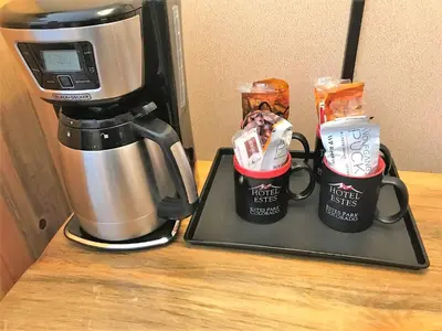 a coffee maker with two coffee cups on a counter at Hotel Estes in Estes Park