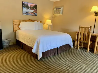 a bedroom with a bed and a desk and a chair at Hotel Estes in Estes Park