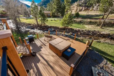 a deck with a bench and a ottoman at 4 Seasons Inn on Fall River in Estes Park
