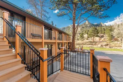 a building with wooden stairs and a fence at 4 Seasons Inn on Fall River in Estes Park