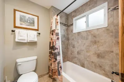 a bathroom with a toilet and a shower and a window at 4 Seasons Inn on Fall River in Estes Park
