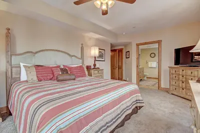 a bedroom with a large bed and a flat screen tv at 3069 Timbers Condo in Keystone