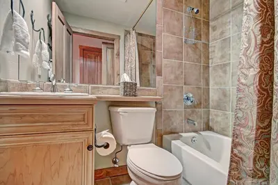 a bathroom with a toilet and a tub and a sink at 3069 Timbers Condo in Keystone