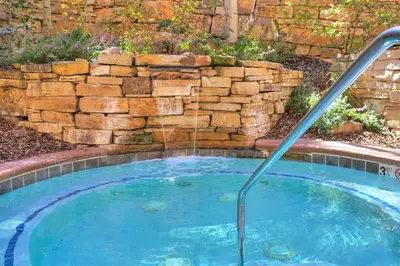 a hot tub in a yard with a stone wall at 3069 Timbers Condo in Keystone