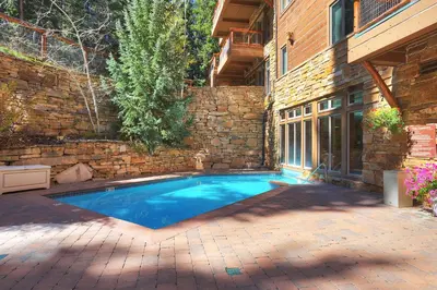 a swimming pool in a yard next to a brick wall at 3069 Timbers Condo in Keystone