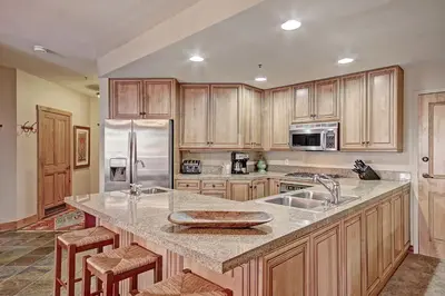 a kitchen with wooden cabinets and stainless steel appliances at 3069 Timbers Condo in Keystone