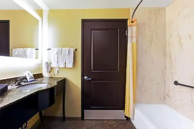 a bathroom with a tub and a shower with a toilet at La Quinta by Wyndham Denver Gateway Park in Denver