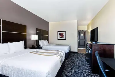 a hotel room with two beds and a flat screen tv at La Quinta by Wyndham Denver Gateway Park in Denver
